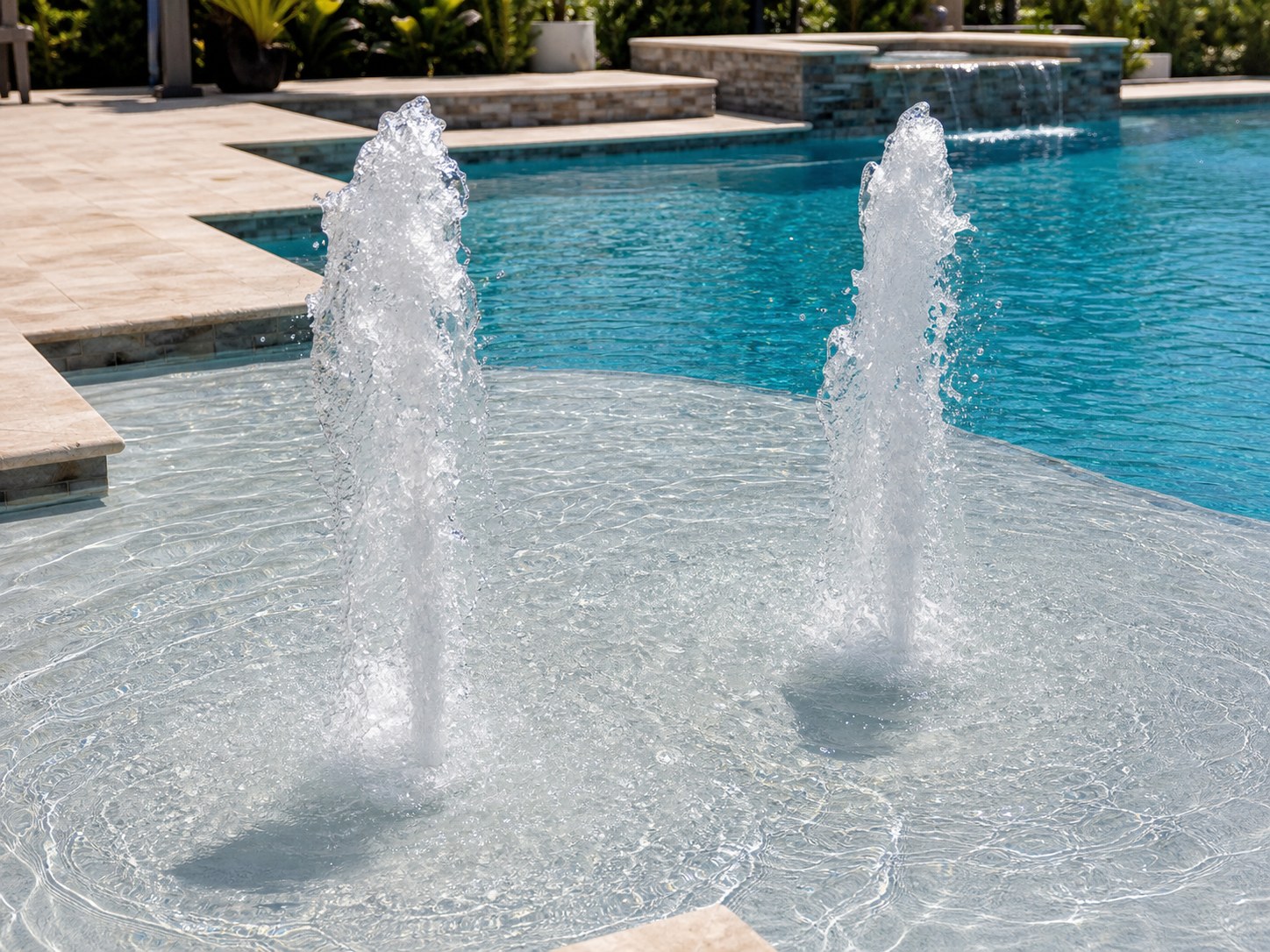 Sun shelf pool bubblers shooting tall water plumes